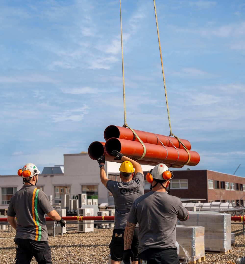 3 riggers kijken naar hijslast